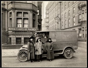 Cuatro mujeres del Cuerpo de Motor de América frente a una ambulancia en Park Avenue en la calle 40 frente al edificio del Cuerpo de Motor de América, Nueva York, 1920